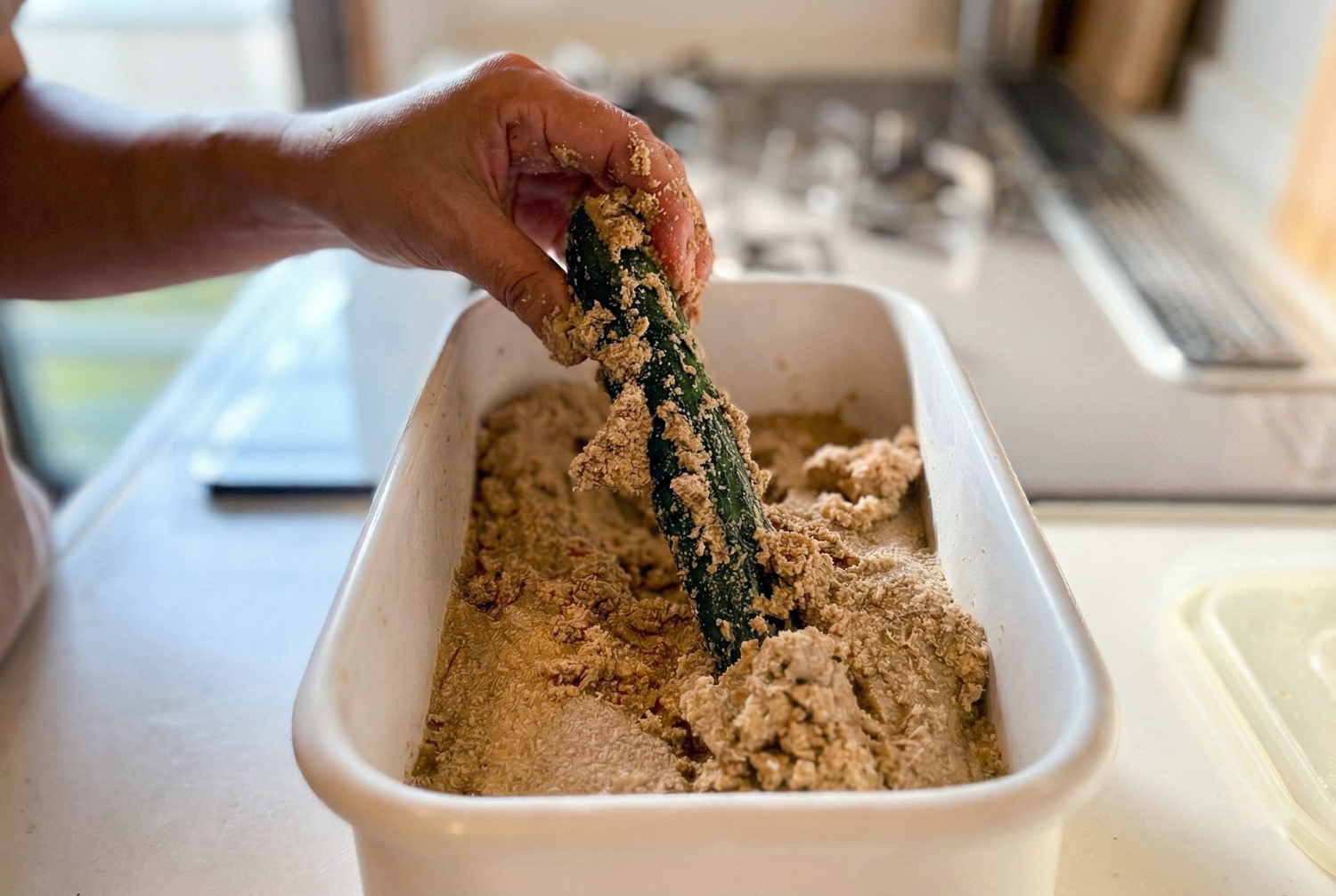 ぬか床からキュウリのぬか漬けを取り出す